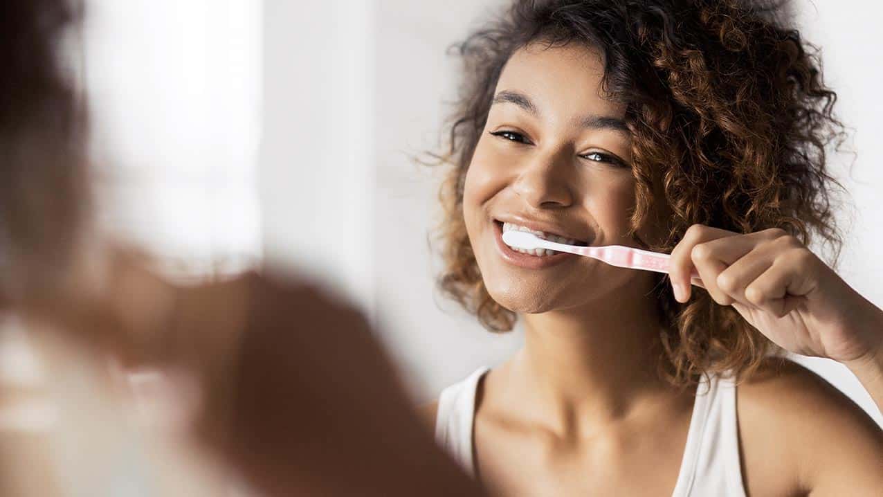 Girl brushing her teeth with whitening toothpaste